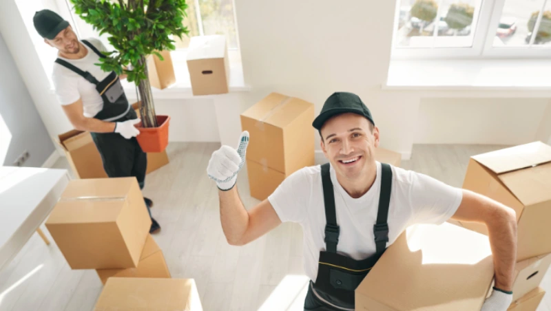 Happy movers celebrating successful move with thumbs up 