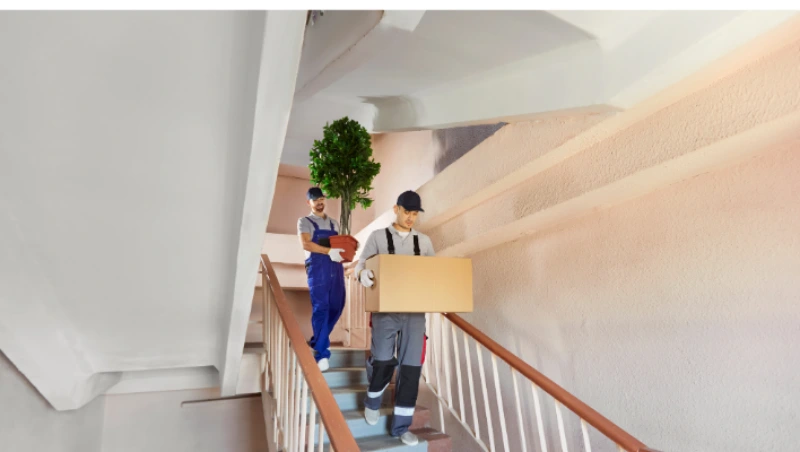 Villa Movers in Dubai carrying moving boxes down residential stairs during villa relocation process