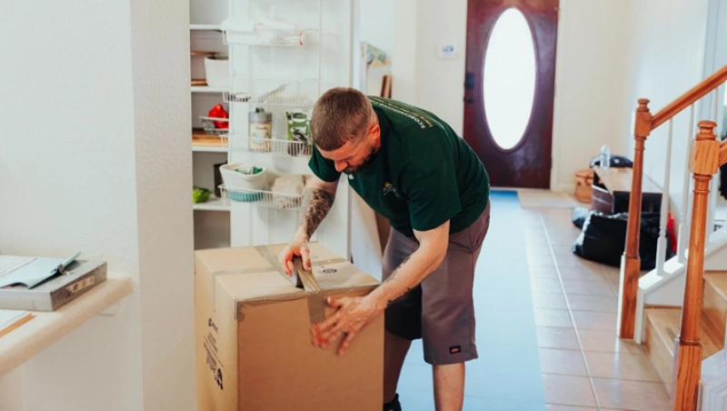 Professional mover carefully taping and securing moving box with precision