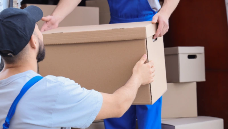 Close-up of movers securing and taping cardboard 
Villa Movers in Dubai boxes for safe transportation